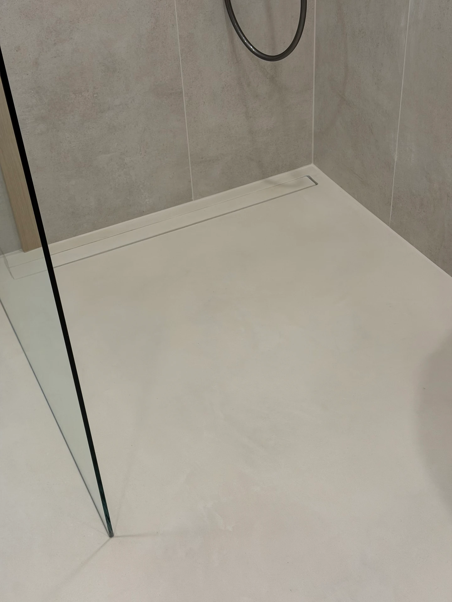 Mikrocement w prysznicu - zdjęcie poglądowe realizacji: bezspoinowa posadzka z mikrocementu w prysznicu ze spadkiem do odpływu liniowego